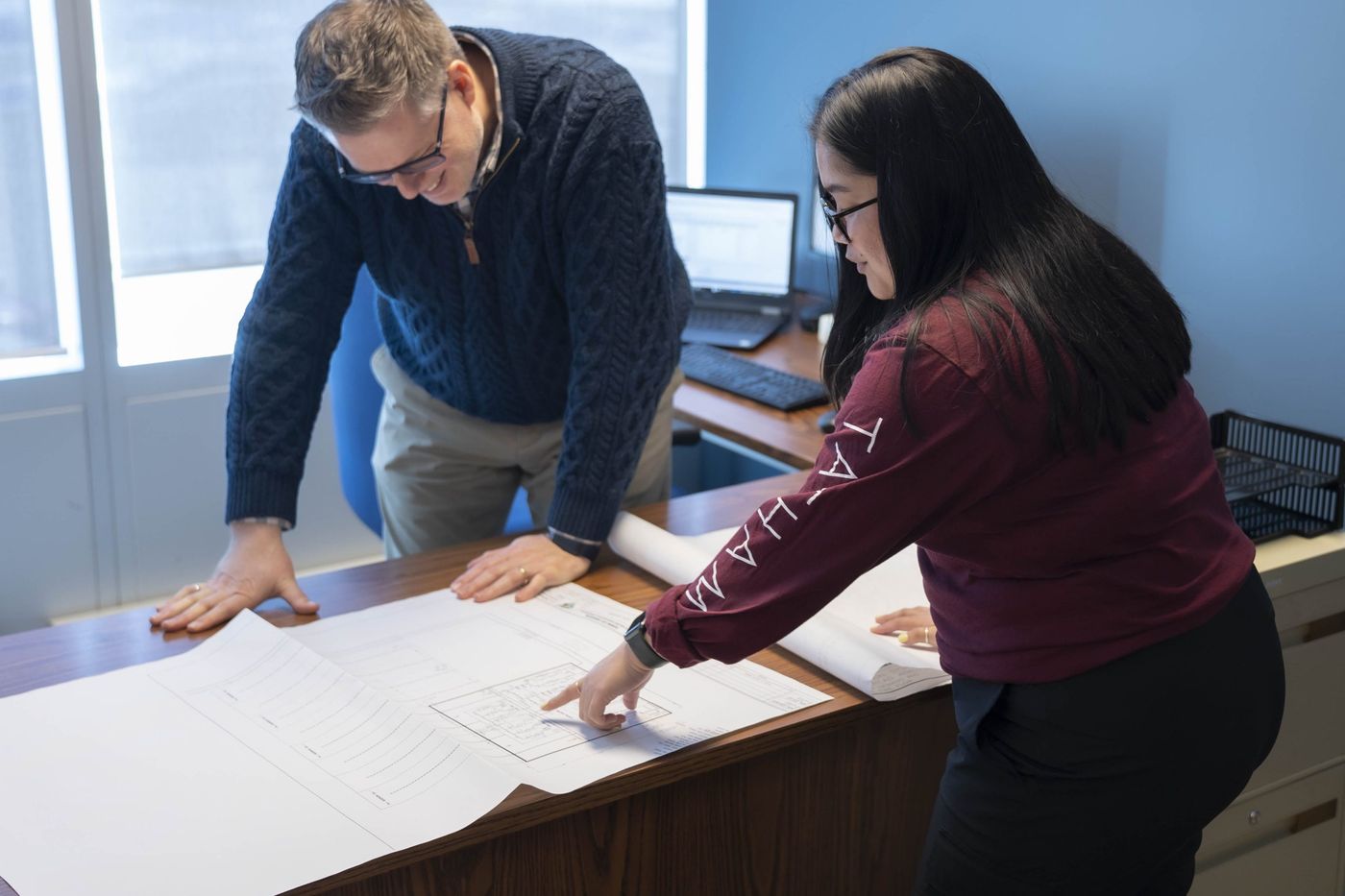 Two Tatham Engineering staff members reviewing drawings in the office